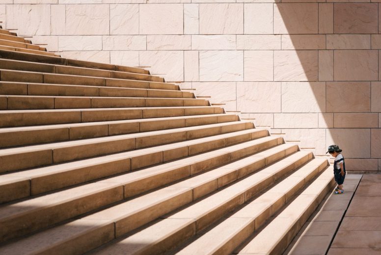 toddler's standing in front of beige concrete stair